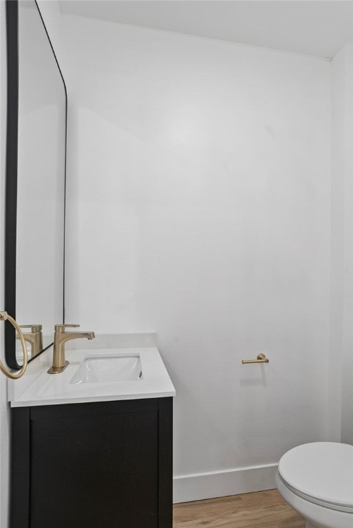 bathroom featuring vanity, hardwood / wood-style flooring, and toilet