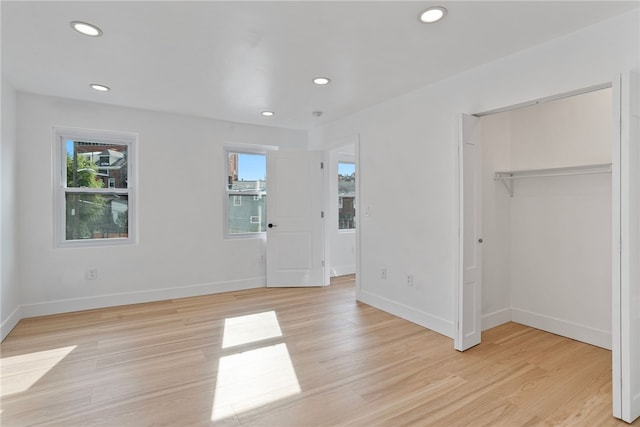 unfurnished bedroom with light hardwood / wood-style flooring and a closet