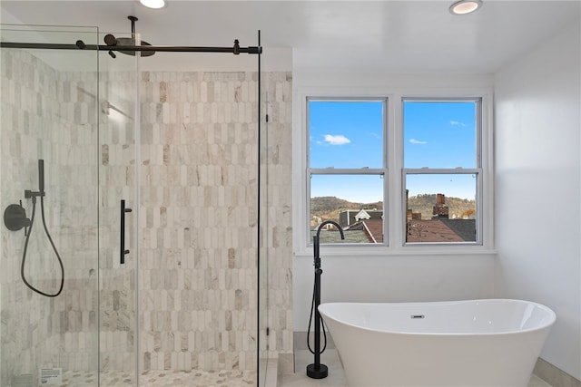 bathroom featuring a wealth of natural light and separate shower and tub