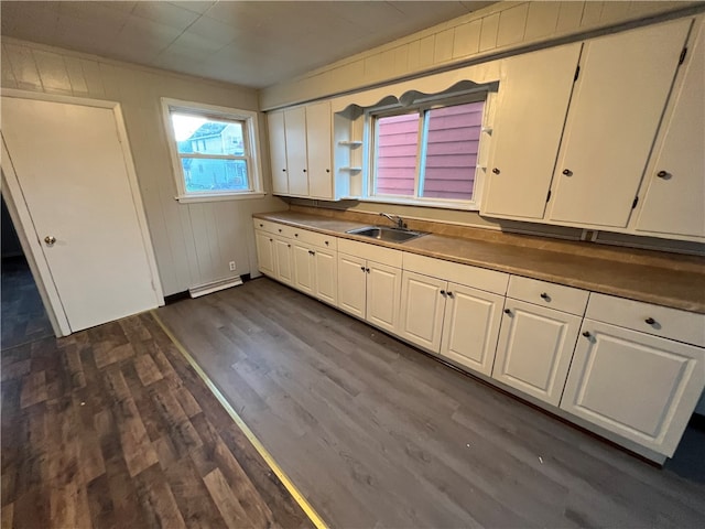 kitchen with dark wood-type flooring, baseboard heating, and white cabinets