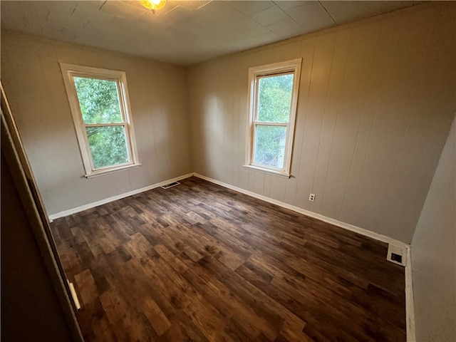 unfurnished room with dark wood-type flooring