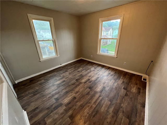 unfurnished room featuring dark hardwood / wood-style flooring and plenty of natural light