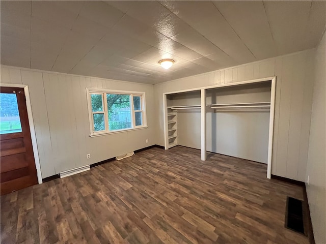 unfurnished bedroom featuring a closet and dark hardwood / wood-style flooring