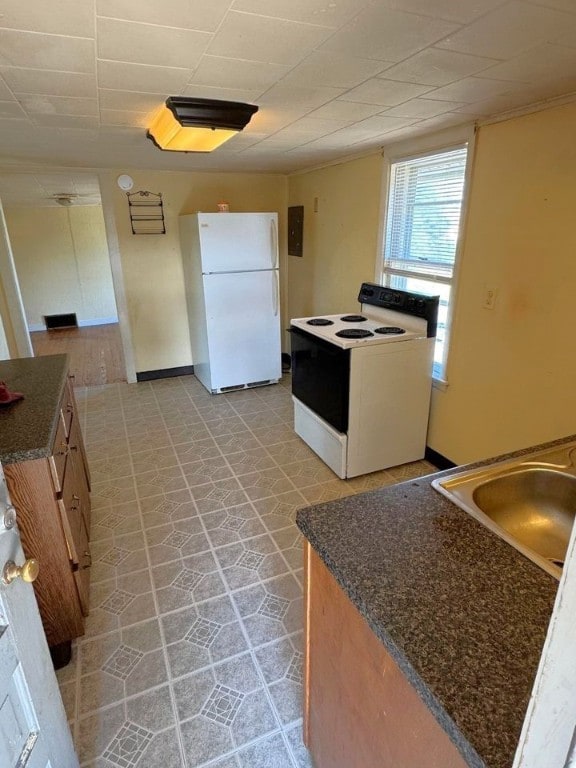 kitchen featuring white appliances, light tile patterned floors, and sink