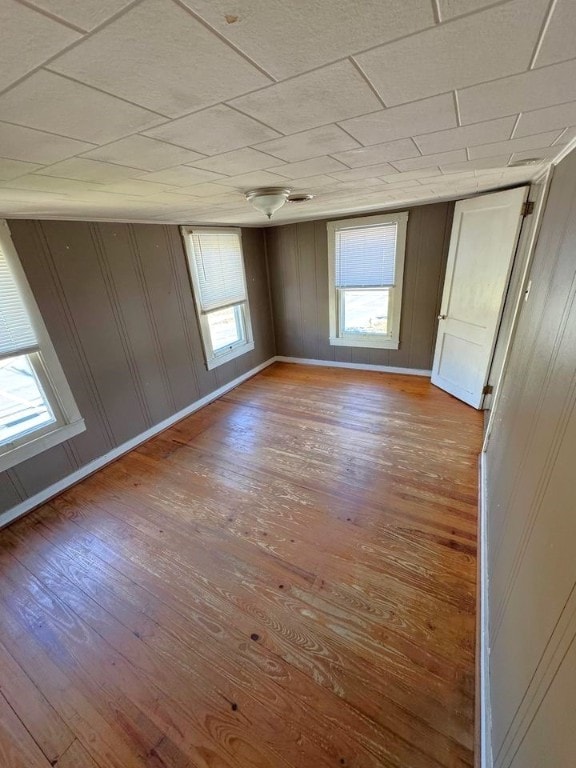 empty room with wood walls and hardwood / wood-style flooring