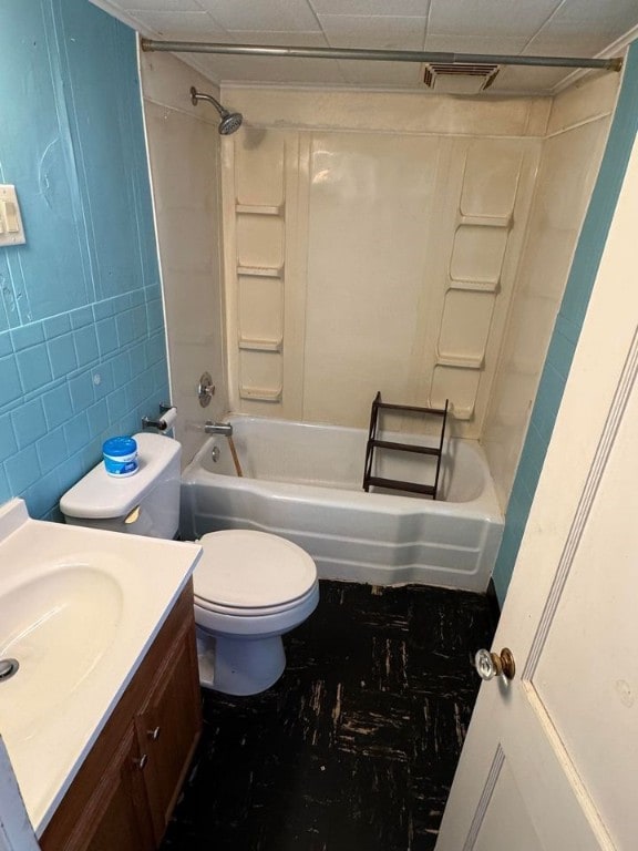 full bathroom with tile walls, vanity, washtub / shower combination, and toilet