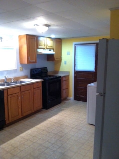 kitchen featuring washer / clothes dryer, black appliances, and sink