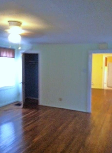 spare room with dark wood-type flooring and ceiling fan