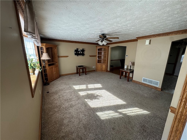 unfurnished living room with crown molding, a textured ceiling, carpet, and ceiling fan