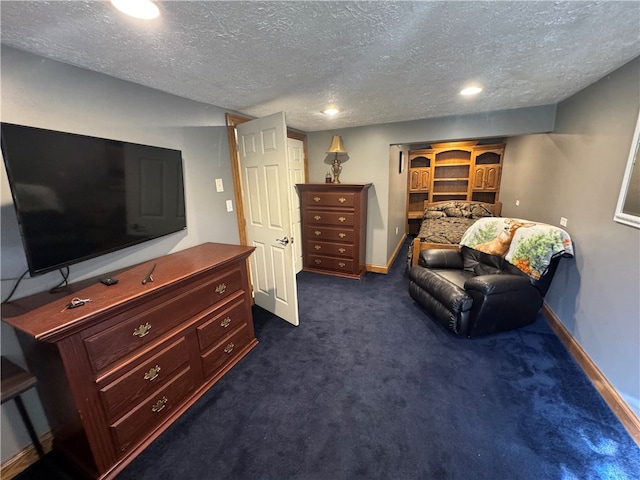 sitting room featuring a textured ceiling and dark colored carpet