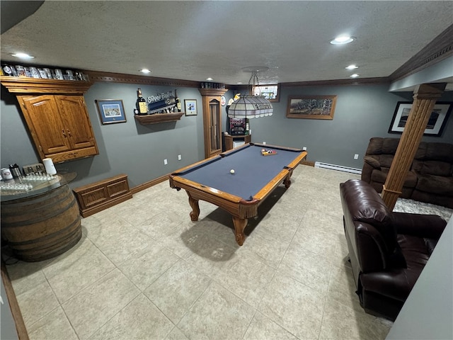 rec room with pool table, a textured ceiling, ornate columns, baseboard heating, and ornamental molding