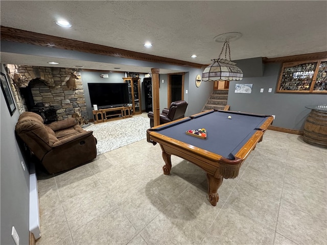 game room with a textured ceiling, billiards, tile patterned floors, and a fireplace