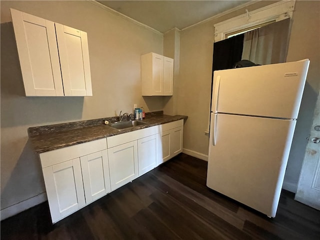 kitchen with dark hardwood / wood-style flooring, white cabinets, sink, and white refrigerator