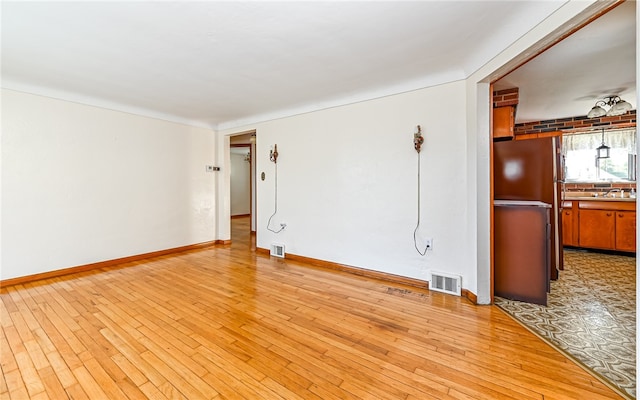 empty room with light hardwood / wood-style flooring and sink