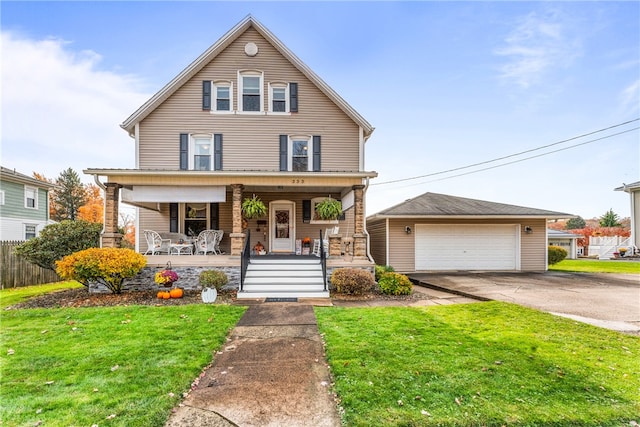 front facade featuring an outbuilding, a front yard, covered porch, and a garage