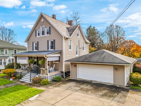 view of front of property featuring a porch, an outbuilding, and a garage