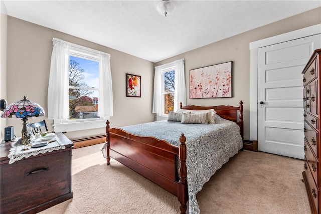 carpeted bedroom featuring multiple windows and baseboard heating