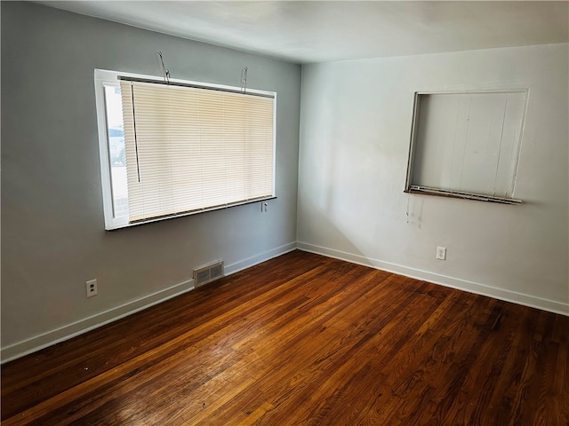 unfurnished room with dark hardwood / wood-style flooring