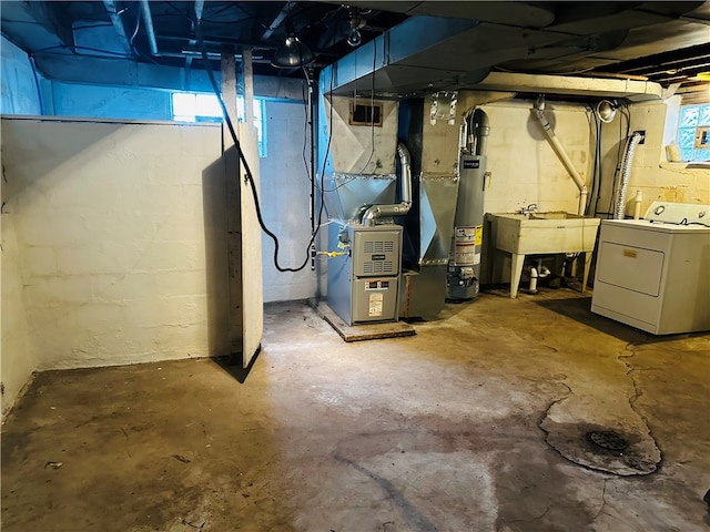 basement with sink, gas water heater, a healthy amount of sunlight, and washer / clothes dryer