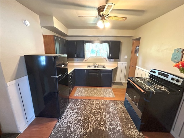 kitchen with sink, black appliances, ceiling fan, and dark hardwood / wood-style flooring