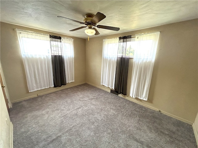 empty room with carpet, plenty of natural light, and ceiling fan