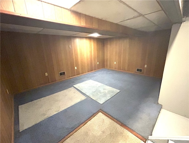 basement featuring wood walls and carpet