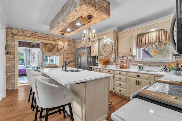 kitchen featuring a center island with sink, sink, appliances with stainless steel finishes, and light hardwood / wood-style flooring