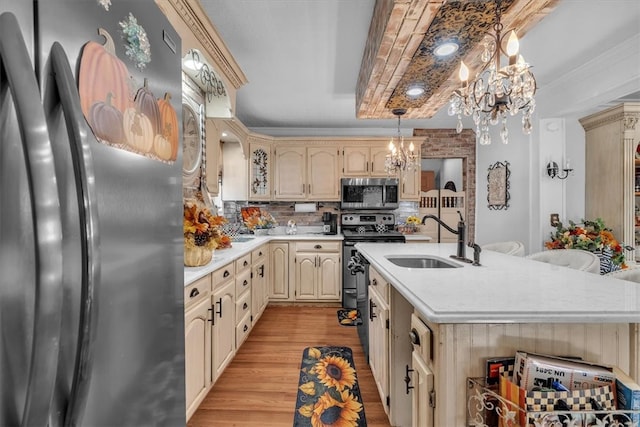 kitchen featuring backsplash, appliances with stainless steel finishes, a chandelier, light hardwood / wood-style floors, and sink