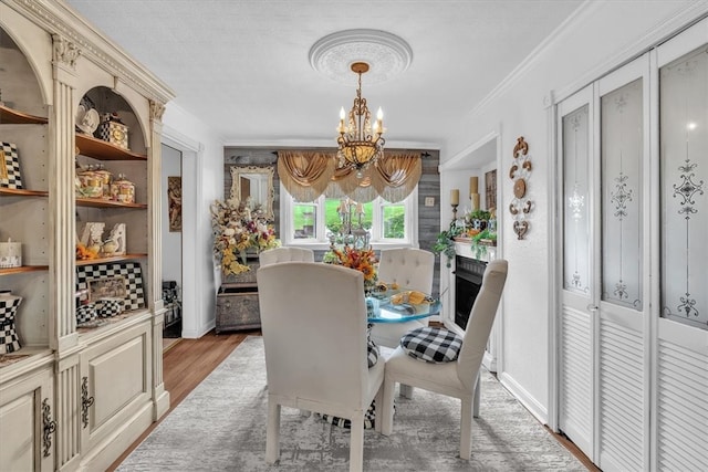 dining area with ornamental molding, an inviting chandelier, and hardwood / wood-style floors