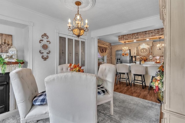 dining space featuring ornamental molding, a chandelier, and hardwood / wood-style floors