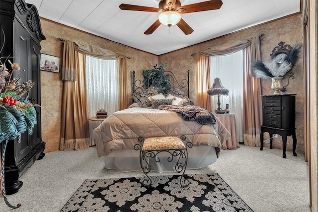 carpeted bedroom featuring multiple windows and ceiling fan