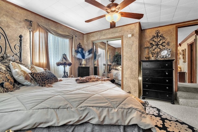 carpeted bedroom with ornamental molding, a closet, and ceiling fan