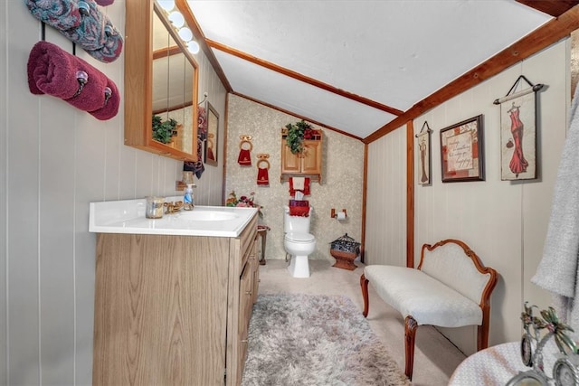 bathroom featuring vanity, toilet, ornamental molding, and lofted ceiling