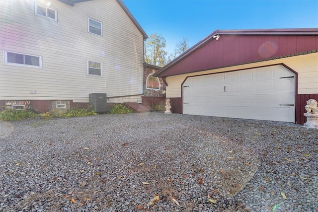 view of side of home with a garage and cooling unit