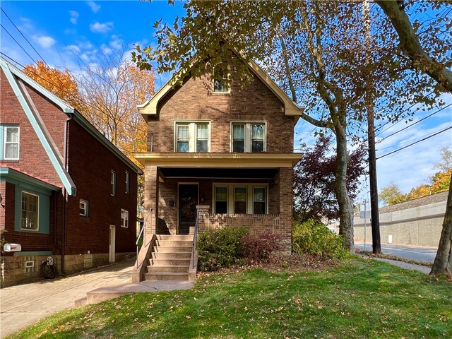 view of front facade with covered porch and a front yard