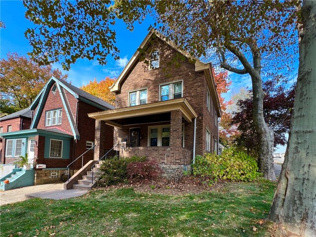 view of front of home with covered porch and a front yard