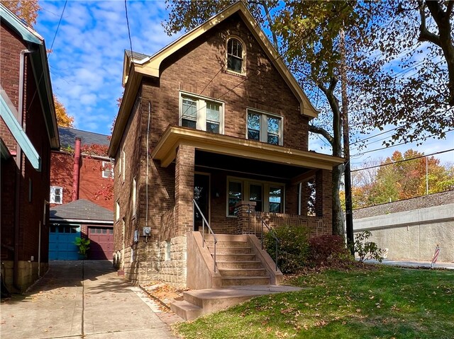 view of front facade featuring covered porch, a garage, and a front lawn