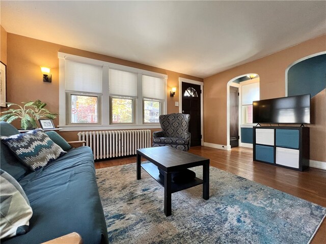 living room featuring radiator heating unit and hardwood / wood-style flooring