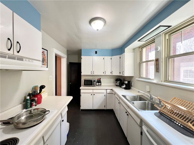 kitchen with sink, stovetop, and white cabinets