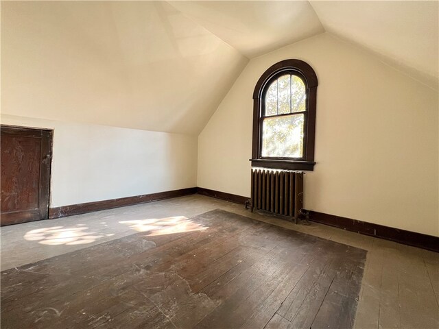 bonus room featuring lofted ceiling, radiator heating unit, and hardwood / wood-style floors