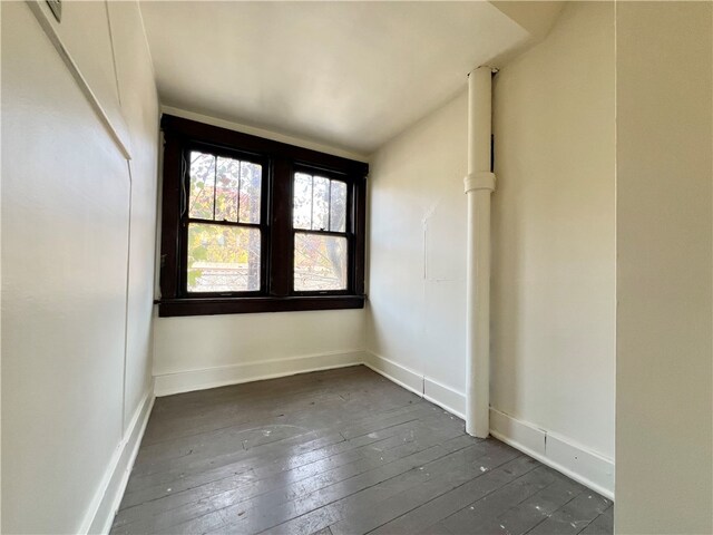 unfurnished room with dark wood-type flooring