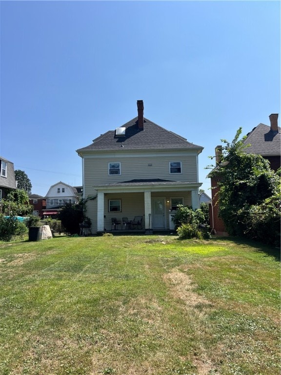 rear view of property with a yard