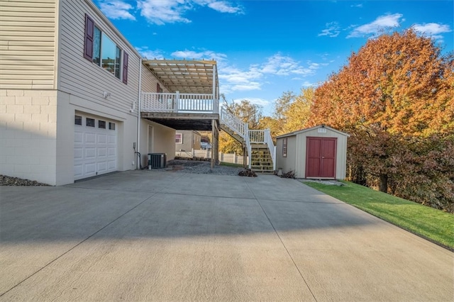 view of home's exterior featuring central air condition unit, a shed, and a garage