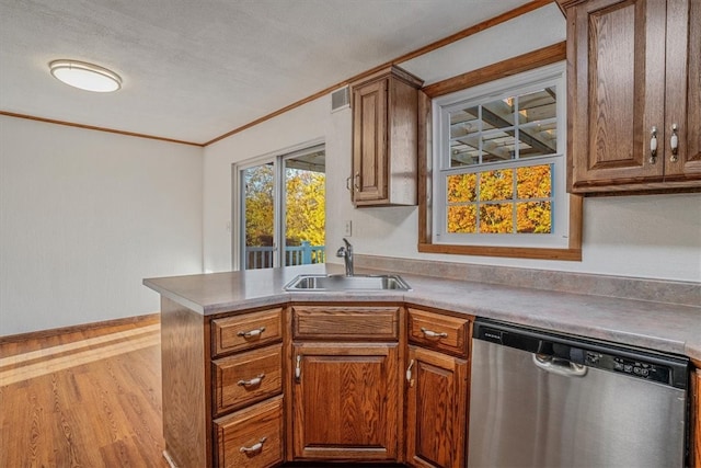 kitchen featuring a textured ceiling, stainless steel dishwasher, light wood-type flooring, crown molding, and sink