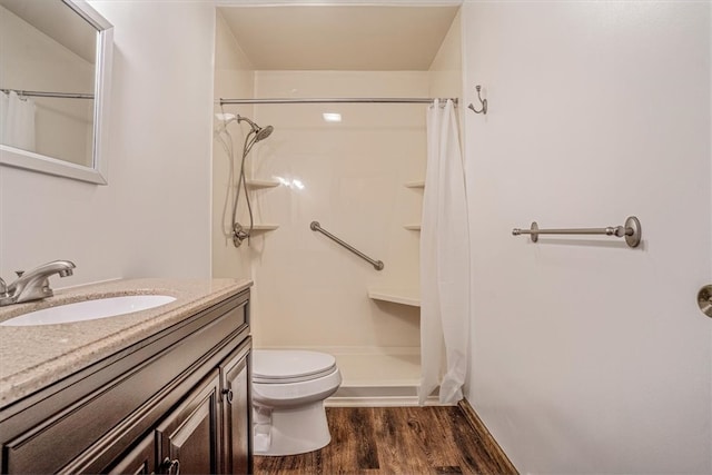 bathroom featuring vanity, toilet, hardwood / wood-style flooring, and walk in shower