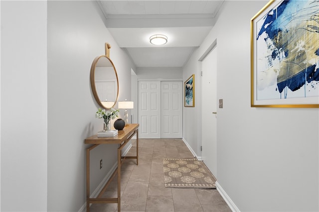 hall featuring crown molding and light tile patterned flooring