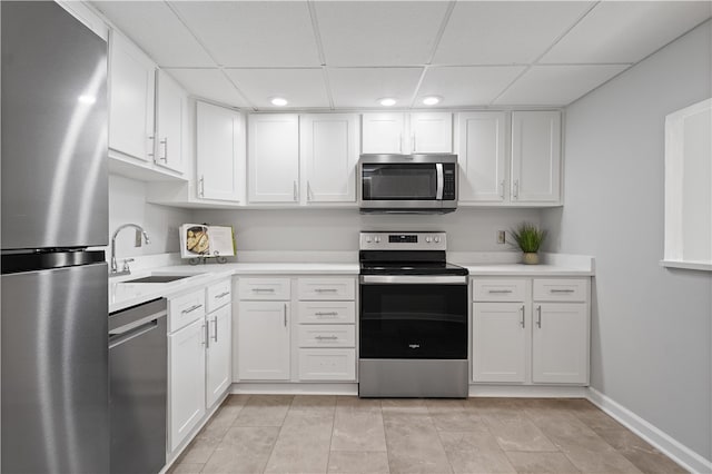 kitchen with white cabinetry, appliances with stainless steel finishes, sink, and a drop ceiling