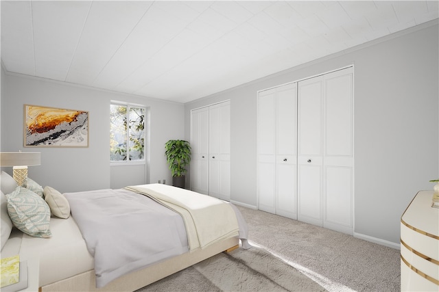 carpeted bedroom featuring multiple closets and ornamental molding