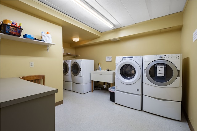 laundry area with independent washer and dryer and sink