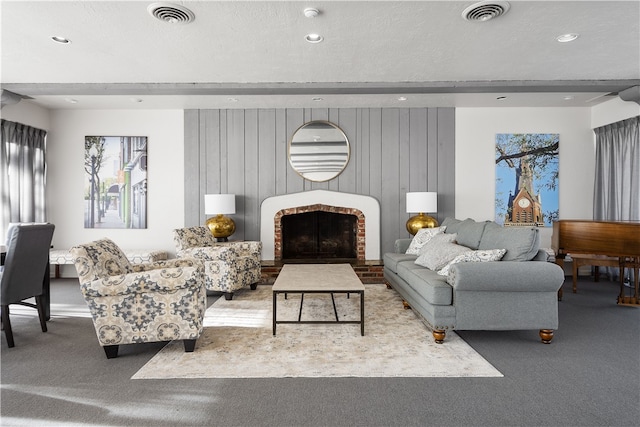 living room with carpet, wood walls, a textured ceiling, and a fireplace